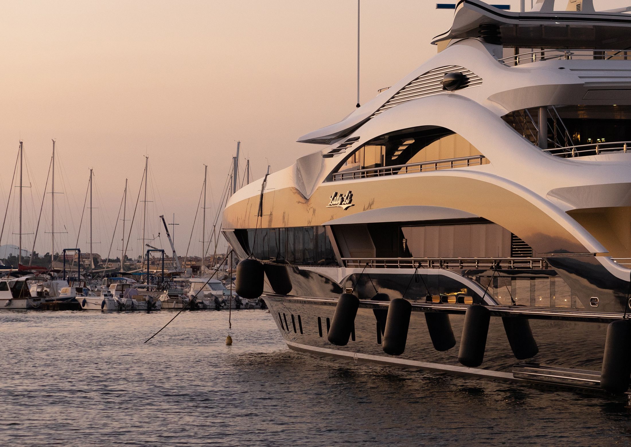 A super yacht in a marina at dusk