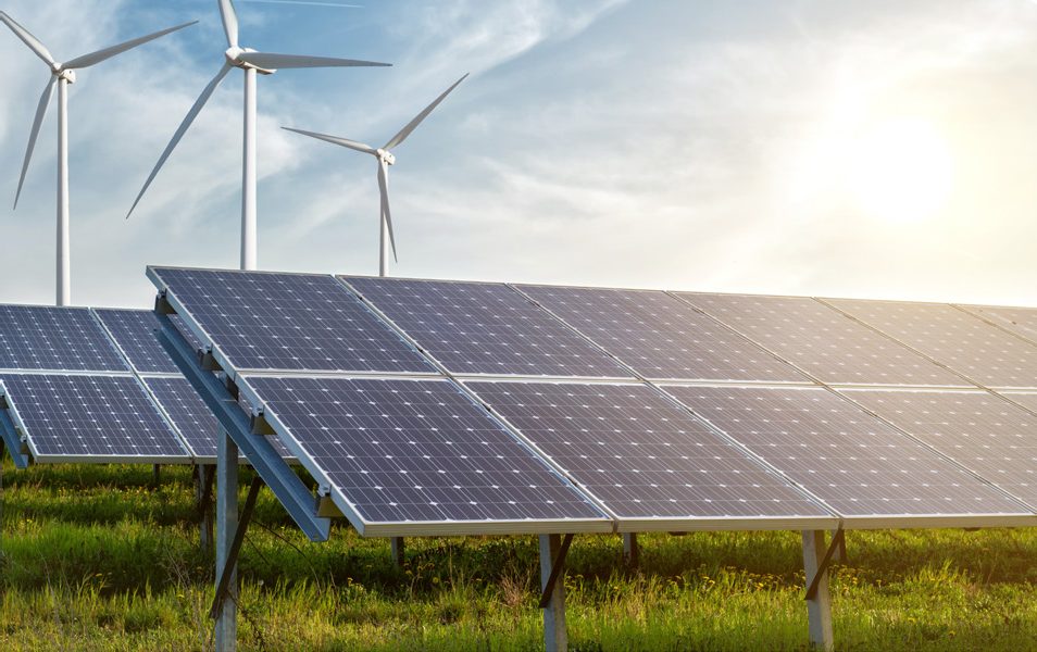 Solar panels and wind turbines under a bright sky
